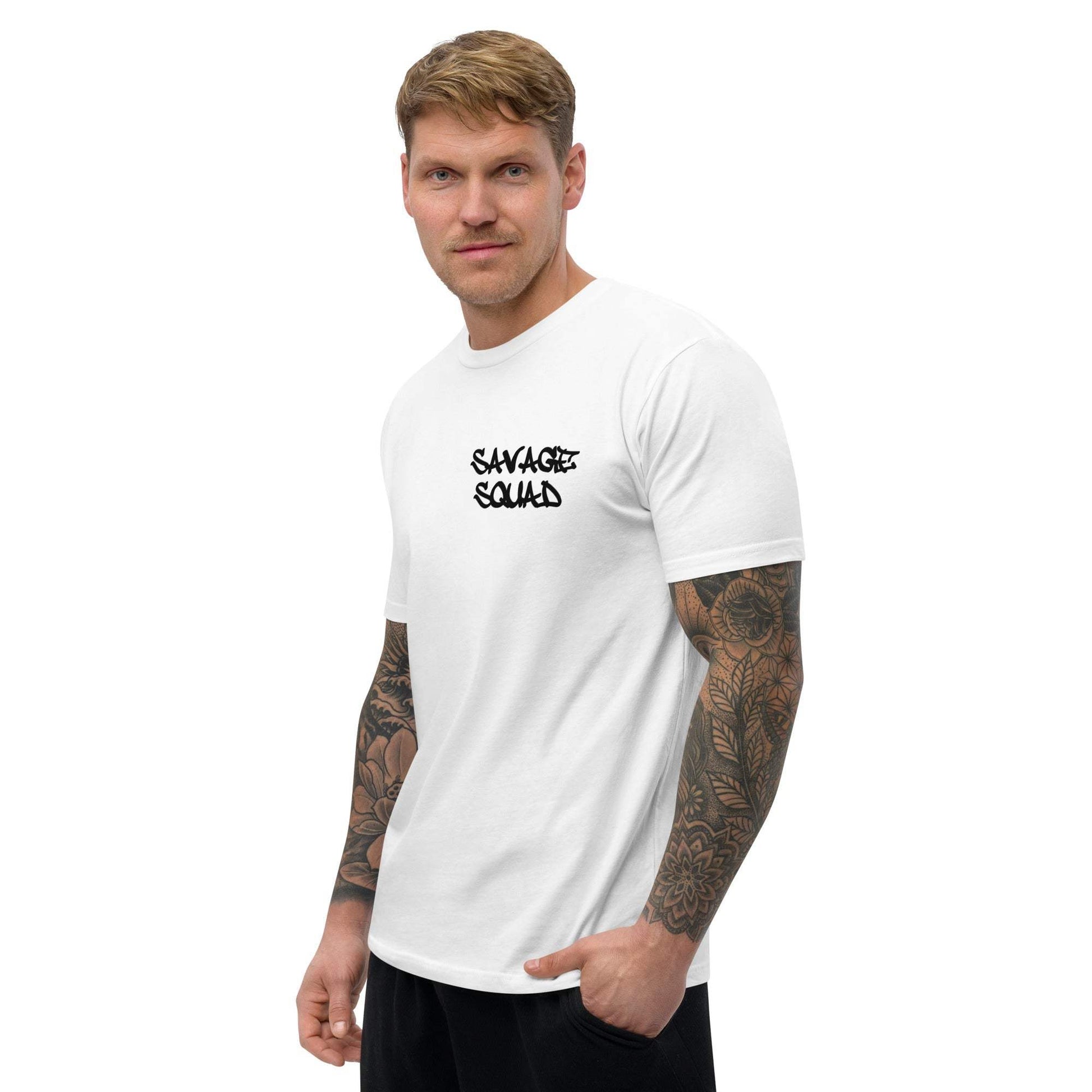 Man wearing a fitted white Logo Tee, featuring printed design on the chest, with tattooed arms.